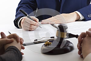 Hands of wife, husband signing decree of divorce, dissolution, canceling marriage, legal separation documents, filing