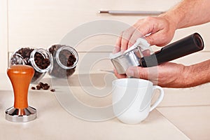 Hands wipes holder before making espresso above table