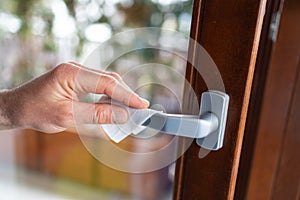 Hands wiping door handle with disinfectant wipe