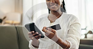 Hands, woman and credit card with smartphone on sofa for online shopping, payment and fintech at home. Closeup, mobile