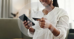 Hands, woman and credit card with smartphone on sofa for online shopping, payment and fintech at home. Closeup, mobile