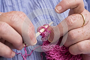Hands of a woman crocheting with ivory crochet