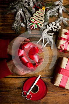 Hands of woman decorating Christmas gifts and decorations