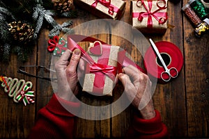 Hands of woman decorating Christmas gifts and decorations