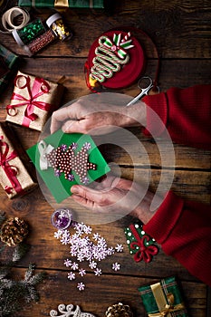 Hands of woman decorating Christmas gifts and decorations