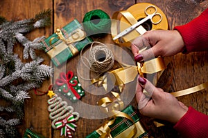 Hands of woman decorating Christmas gifts and decorations