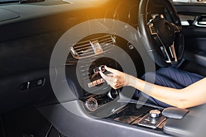 Hands woman driver turning on car air condition system,Button on dashboard in modern car panel,Auto car air conditioner