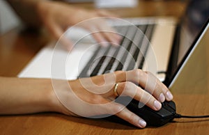 Hands of woman in front of laptop at the work place