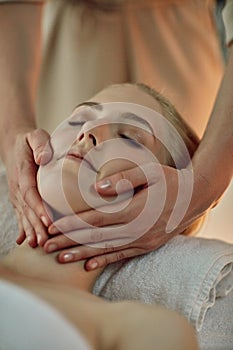 Hands, woman and head on massage table at spa for health, wellness and relax for hospitality at resort. Masseuse, people