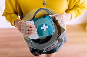 Hands woman holding a medicine first aid kit bag putting into handbag,Healthy and lifestyle concept