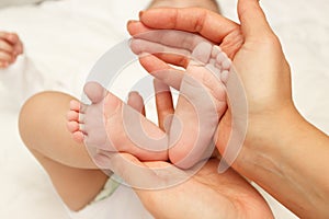 Hands of woman holds baby, blurred background