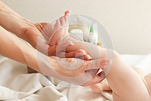 Hands of woman holds baby foot