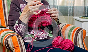 Hands of woman knitting a wool sweater