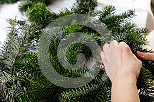 Hands of a woman make Christmas Advent wreath from fir twigs