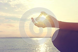 Hands of woman meditating on a yoga pose on the beach