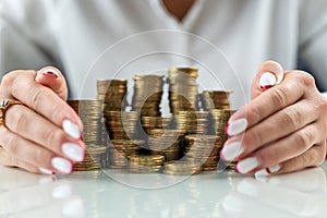 hands of a woman on a mirrored table with a roller coaster with coins hugging money.