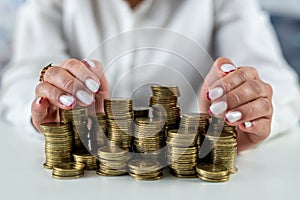 hands of a woman on a mirrored table with a roller coaster with coins hugging money.