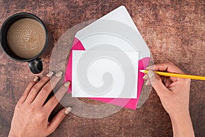 Hands Of Woman With Pencil, Blank Paper, Envelope And Coffee Cup Over Wooden Background. Businesswoman Having Drink And