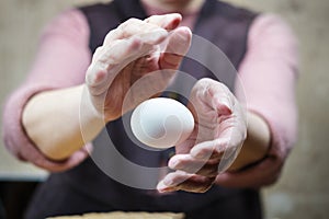 Hands of a woman perform a magic trick with the egg. Levitation of the egg in the air