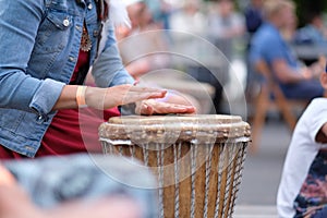 The hands of a woman playing on an African djembe drum