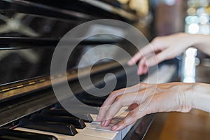 Hands of woman playing grand piano in musical school.Two hand with different level and keyboard.