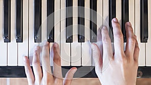 Hands of woman playing grand piano in musical school.Two hand with different level and keyboard.Blur background.