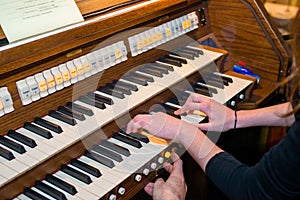 Hands of a woman playing the pipe organ