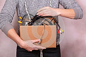 Hands of woman sorting through electronic cables and gadgets