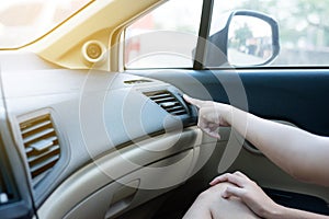 Hands of woman turning on car air conditioning system,Button on dashboard in car panel