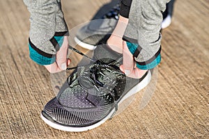 Hands of a woman tying the shoelaces of her comfortable and flex