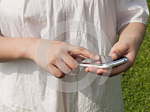 Hands of a woman using cellular phone