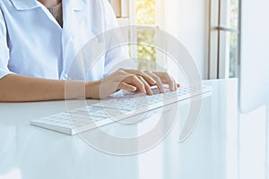 Hands woman using computer keyboard on desk in office room,Finger typing close up photo