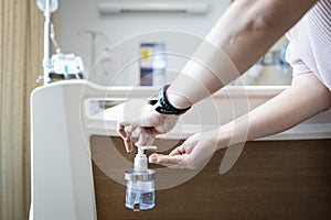 Hands of woman using hand sanitizer before touching a patient on the bed at hospital while visiting,antiseptic liquid for hand