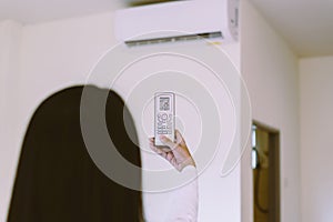 Hands woman using remote control to activating 25 degree celsius,Concept save energy and save world