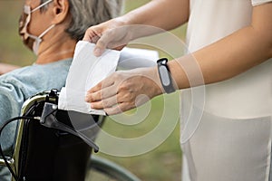 Hands of woman using tissue paper entwine handlebar of   wheelchair instead of touch her hands,wheelchair at the hospital,avoid