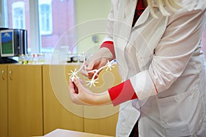 Hands of woman in white showing workpiece with photo