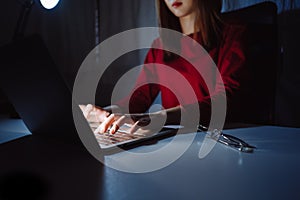 Hands of woman working late time at night typing keyboard laptop computer home office workhard photo