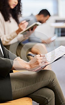 Hands, woman and writing in waiting room for interview, recruitment and documents to prepare for job. Group, people and