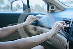 Hands of women turning on car air conditioning system,Button on dashboard in car panel