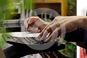 hands of women who count the estimate on the calculator and record the data