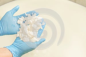 Hands work on cheese production