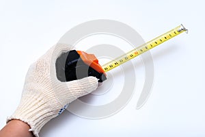 Hands of a worker, builder in protective gloves halding a ruler, using tape measure against white background