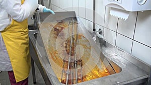 Hands of worker cleans fat on the industrial grill.