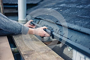 Hands of worker fixing drain