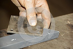 Hands of a worker holding metal