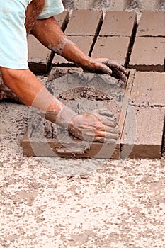Hands of worker making bricks