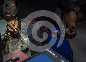 Worker making faceting of semi-precious stone on grinding machine in the jewelry workshop photo