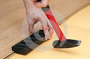Hands of a worker mounting laminated floor