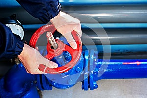 The hands of the worker Unscrew rotate the red valve to supply the gas supply. Top view close-up photo