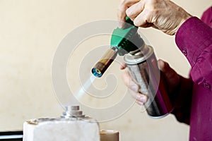 hands of a worker use gas burner in a workshop v